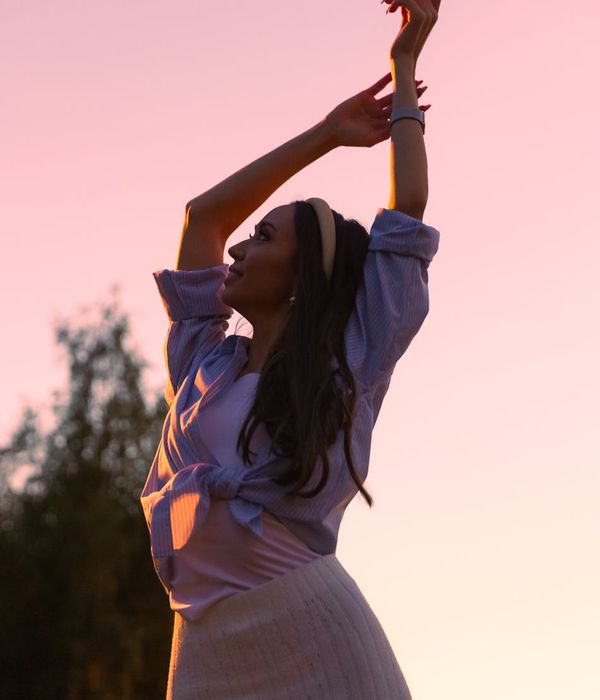 Woman in a graceful yoga pose with magenta light accents.